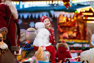 Child on Christmas fair. Kid riding Xmas carousel