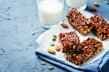 Honey nuts bars with milk on a wood background. toning. selective focus