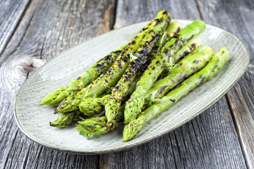 Barbecue green asparagus as close-up on a plate