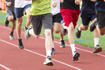 High school boys running in a group on a red track