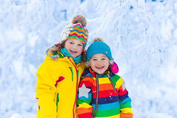 Fototapeta na wymiar Kids play with snow in winter park