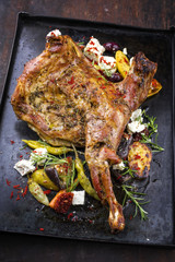 Barbecue lamb shoulder with vegetables and feta as top view on old metal sheet
