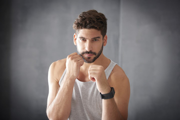 Close-up shot of a young muscular man practising  boxing in gym 