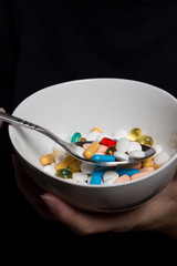 Bowl with spoon full of pills