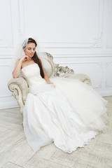 Fototapeta premium Slim beautiful young woman posing in a wedding dress in studio