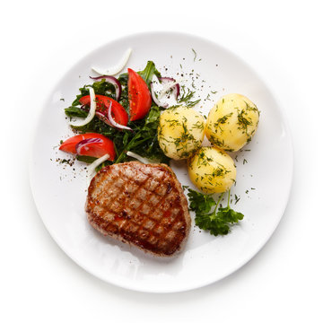 Grilled steak with vegetables on white background 