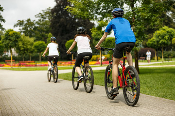 Fototapeta premium Healthy lifestyle - people riding bicycles in city park 