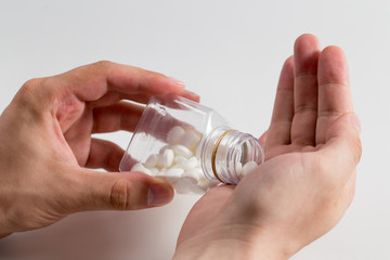Men taking out pills into own hand on a white background