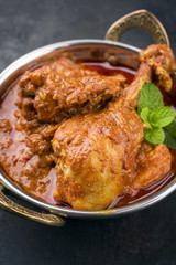 Traditional Indian chicken tikka masala as close-up in a korai