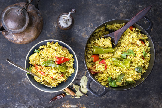 Indian vegetable biryani with sweet pepers and zucchini as close-up in a frying pan