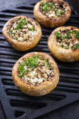 Traditional Italian Mushroom Caps stuffed with Feta as close-up on a grillage