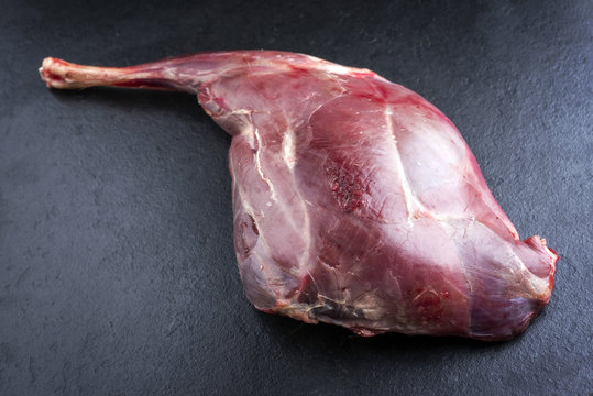 Raw haunch of venison as close-up on a slate slab