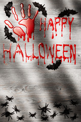 Halloween background, bloody hand print on the wooden board