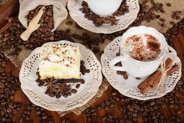 two retro cups with coffee and  foam with milk sprinkledcocoa and coffee cake