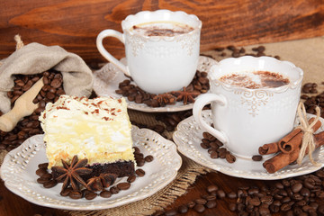 two retro cups with coffee and  foam with milk sprinkledcocoa and coffee cake