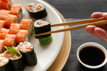 Eating sushi and rolls in japanese restaurant