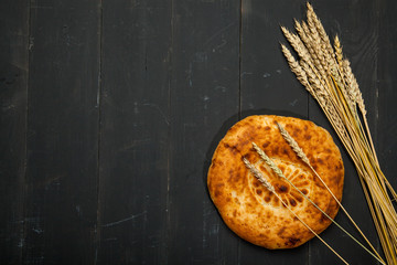 Bread loaf on a black wooden background