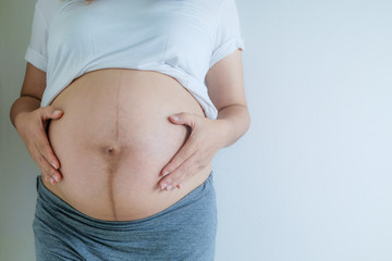 Closeup pregnant woman holding her hands on belly, Happy pregnant woman Concept.