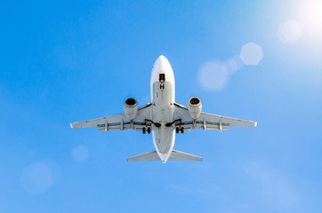 White passenger airplane landing at airport in the blue sky