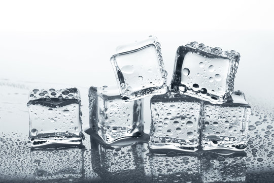 Transparent ice cubes with water drops on glass