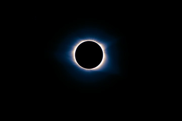 solar eclipse during totality with blue and pink hues