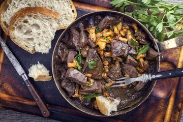 Papier Peint photo Plats de repas Fresh fried veal liver with chanterelle and baguette in sauce as top view in a casserole