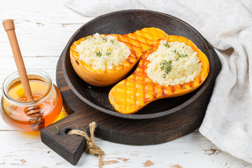 Baked pumpkin stuffed with couscous with honey and thyme. A traditional autumn dish. Selective focus