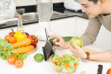 Young asian handsome man preparing food in kitchen at home