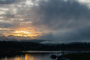 Sunrise on the river with clouds and fog.