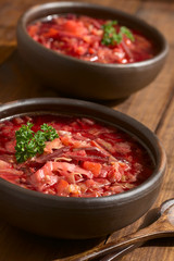 Vegetarische Borschtsch Suppe aus Osteuropa, zubereitet aus rote Bete, Kohl, Karotte, Kartoffeln, Zwiebel, Selleriestange, fotografiert mit natürlichem Licht (Selektiver Fokus)