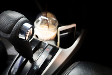 Obraz premium Automatic gear in Drive function. With coffee and mobile phone in box background. Concept of refreshment in car.