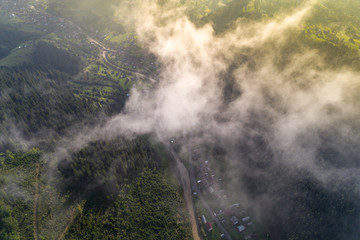Aerial view of the village in the Carpathian mountains with clouds in the foreground