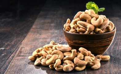 Bowl with cashew nuts on wooden table