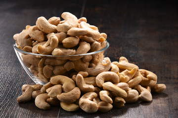 Bowl with cashew nuts on wooden table