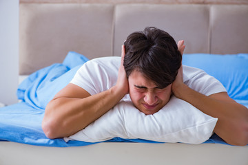 Man suffering from insomnia lying in bed