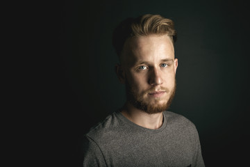 portrait of young man above black background