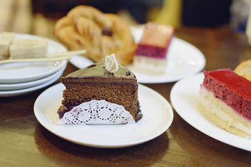 Different cakes lie on a plate in a cafe. Closeup, selective focus.