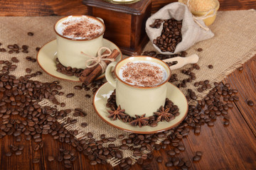 coffee with milk and chocolate foam in brown ceramic cups with vanilla and coffee grains