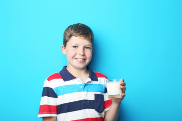 Young boy with glass of milk on blue background
