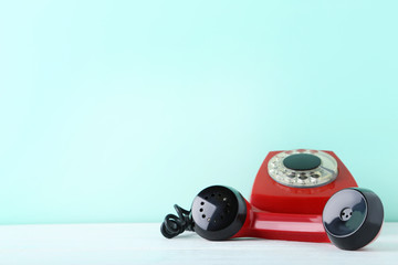 Fototapeta premium Red retro telephone on white wooden table