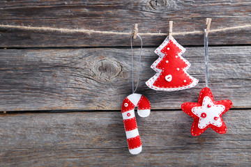 Christmas decorations hanging on rope on wooden background