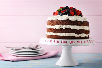 Delicious chocolate biscuit cake with berries on cake stand