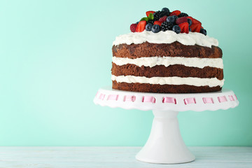 Delicious chocolate biscuit cake with berries on cake stand