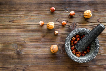 nuts in mortar for making spices in food set on wooden background top view space for text