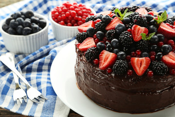 Chocolate cake with berries in plate on wooden table