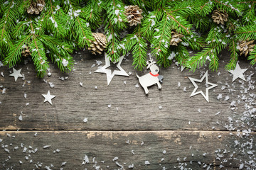 New Year and Christmas background on an old gray wooden background. View from above. Christmas tree branches and snow, gifts and decorations.