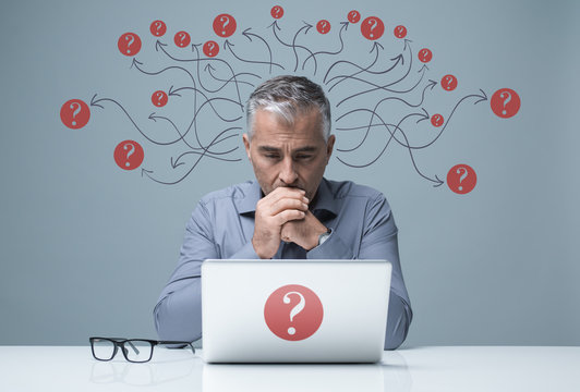 Pensive businessman working with a laptop