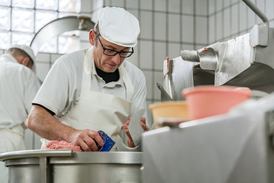 Work in the butchery - butcher grinding meat to make sausages