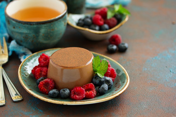 Delicious home-made chocolate dessert Panna cotta. Cream-caramel, caramel custard, with raspberries and blueberries.