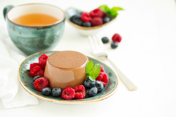 Delicious home-made chocolate dessert Panna cotta. Cream-caramel, caramel custard, with raspberries and blueberries.